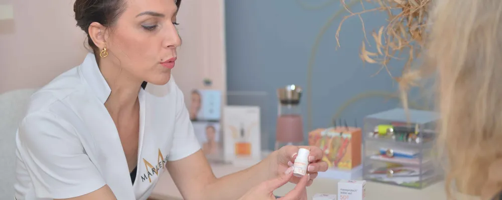 Une esthéticienne présente des produits à une cliente dans l’institut