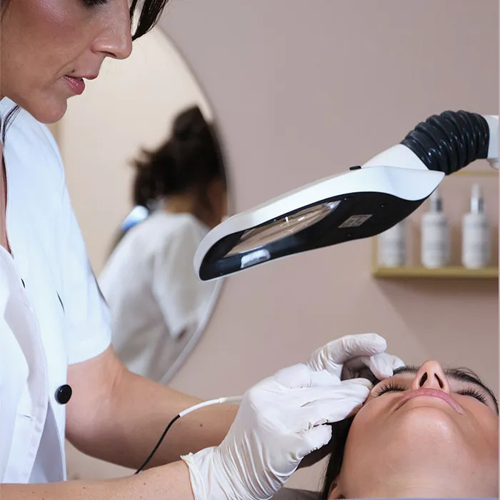 Soin d’épilation du visage sous une lampe loupe