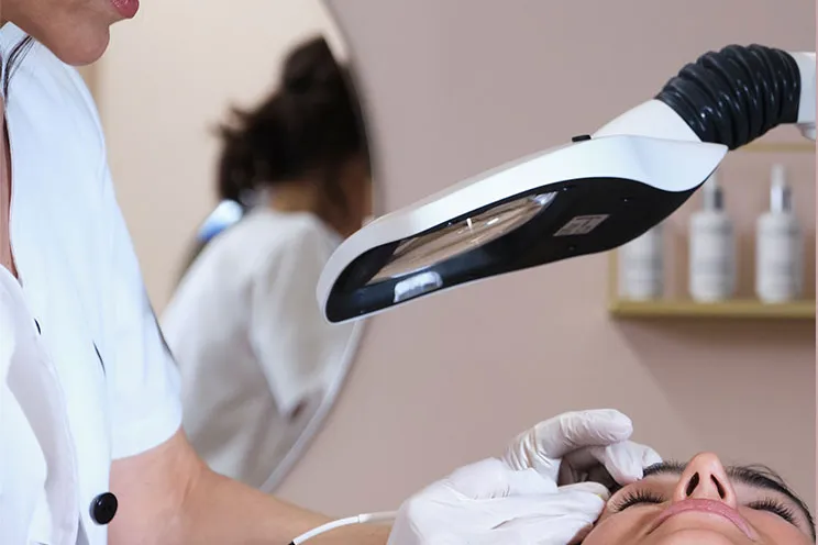 Soin d’épilation du visage sous une lampe loupe