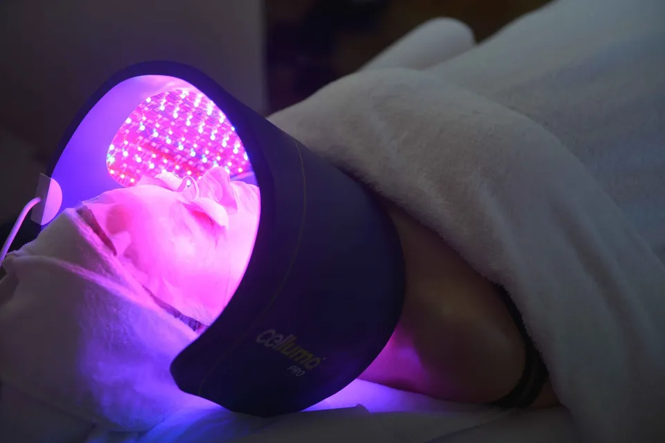 Visage sous un masque LED diffusant une lumière violette