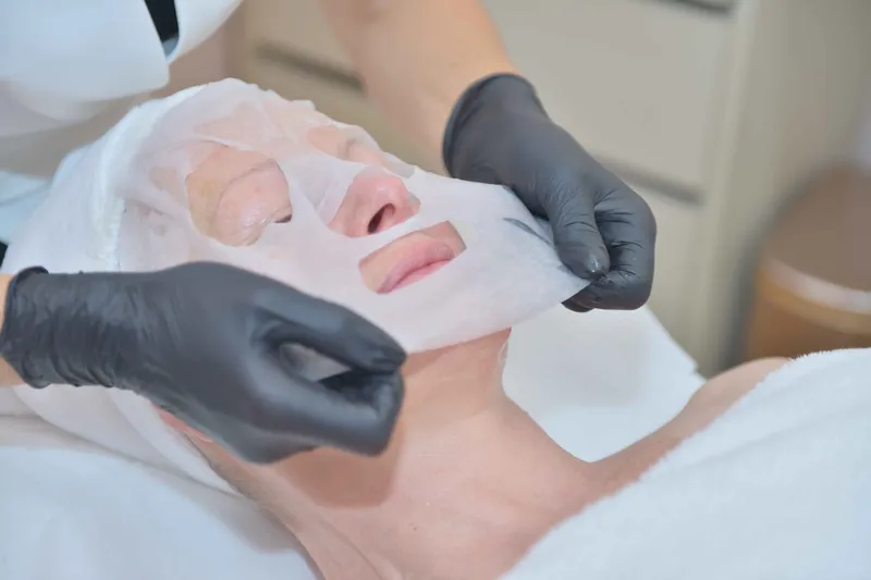 Pose d’un masque en tissu sur le visage d’une cliente