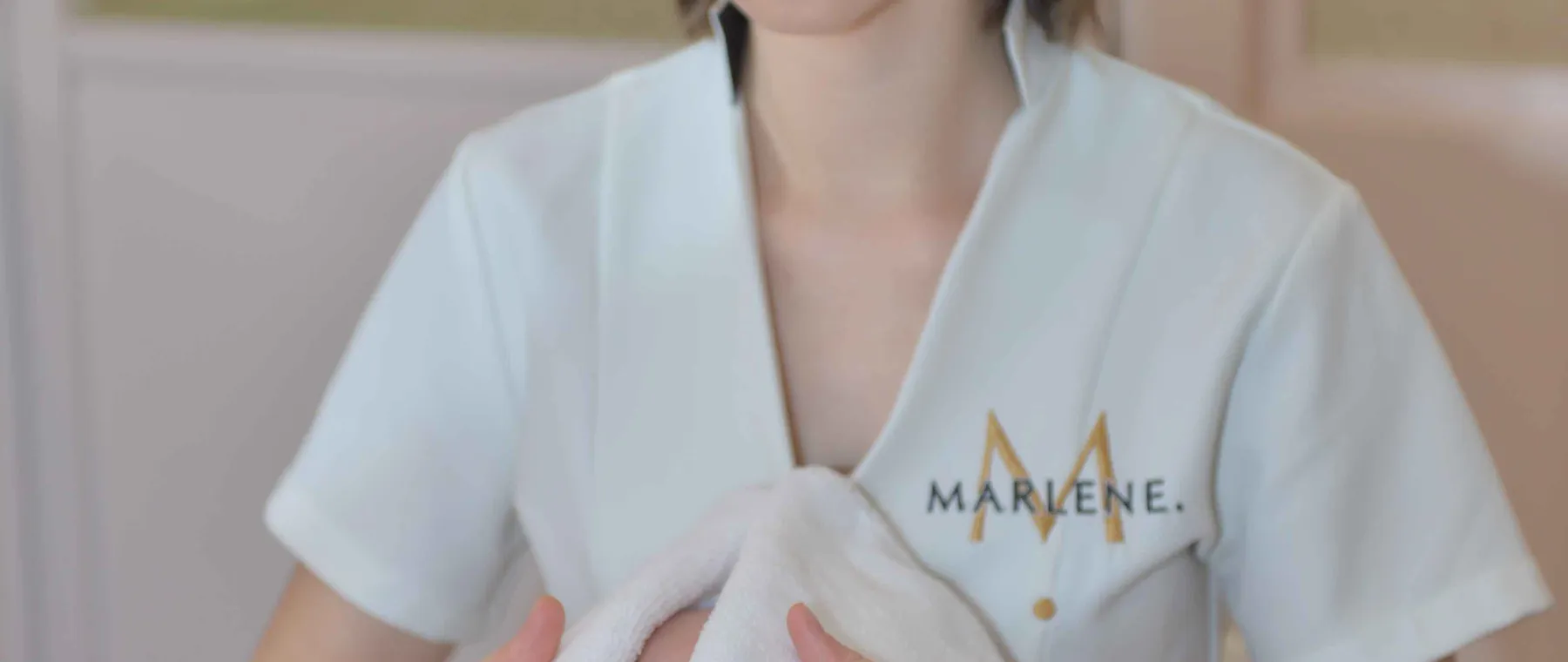 Une esthéticienne applique une serviette sur le visage d’une cliente allongée