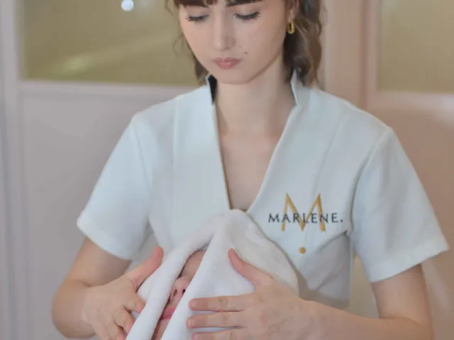 Une esthéticienne applique une serviette sur le visage pendant un soin