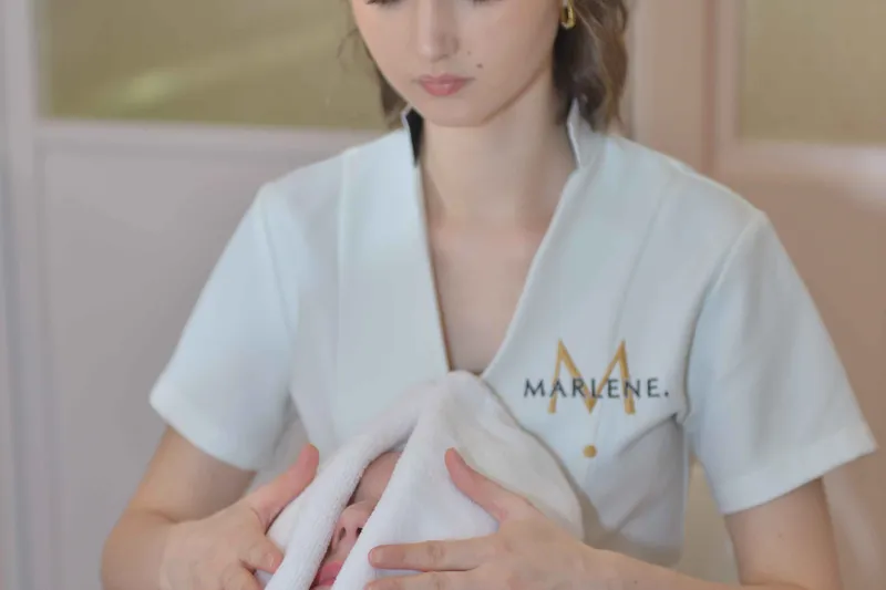 Une esthéticienne applique une serviette sur le visage d’une cliente allongée